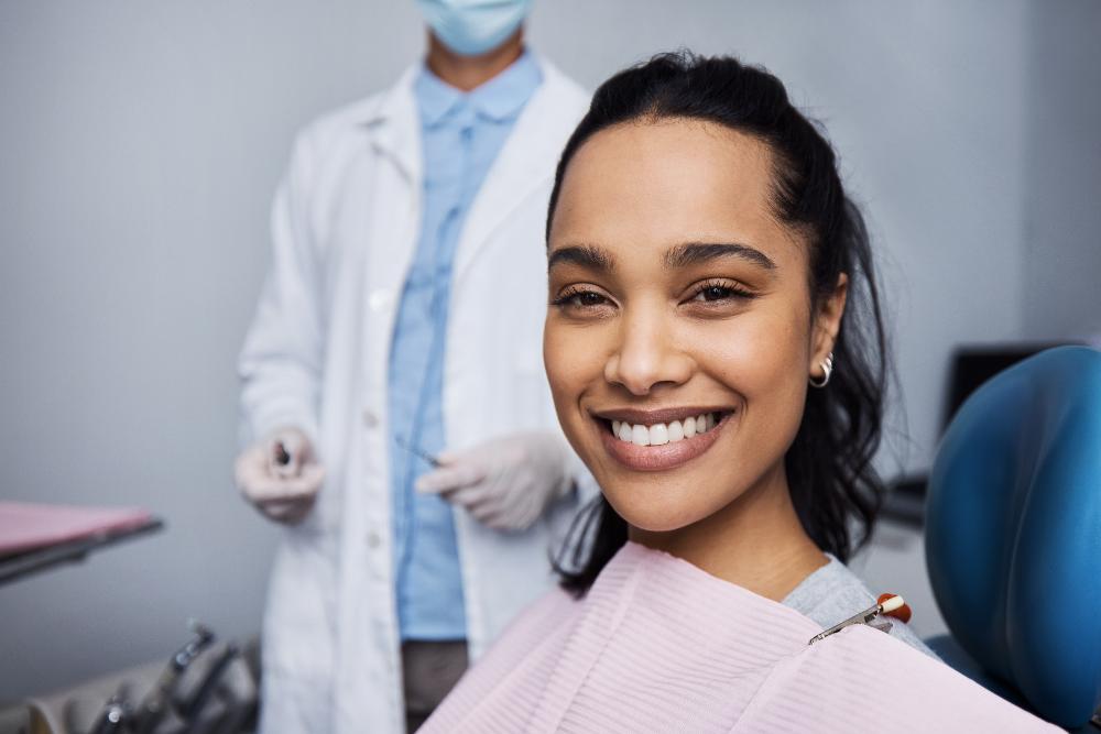 woman sitting in a dental chair while smiling