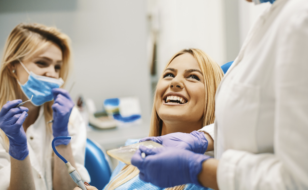 woman with blonde hair smiling with the dentist